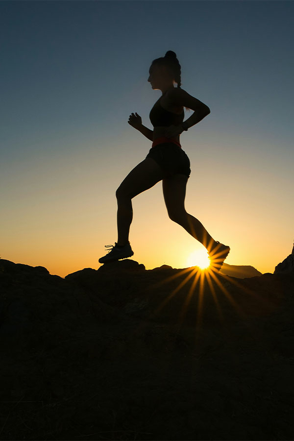 A runner silhouetted against the setting sun